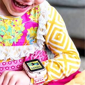 Photo of little kid smiling and laughing while looking down at PlayZoom watch.